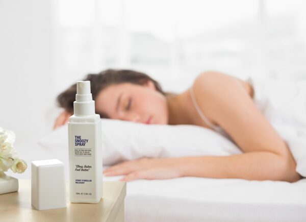 Young woman sleeping in bed after using the Snoozy Pillow spray for sleep
