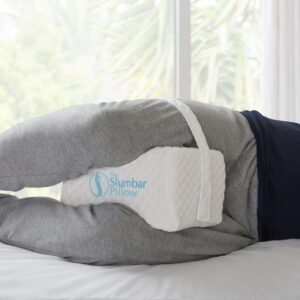 Knee pillow by slumbar with adjustable strap being used with a strap to reduce back pain , Hip pain, Sciatica and improve posture