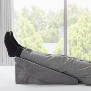 Wedge Pillow by slumbar being used as a leg support, improving blood flow and reducing restless legs.