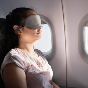 Young Woman Sleeping With Sleep Mask On Airplane