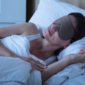 Close-up Of Beautiful Young Woman Sleeping In Bed With Eye Mask