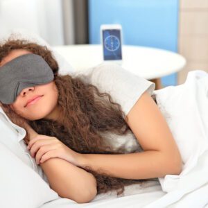 Beautiful girl sleeping in bed wearing a Slumbar eye mask