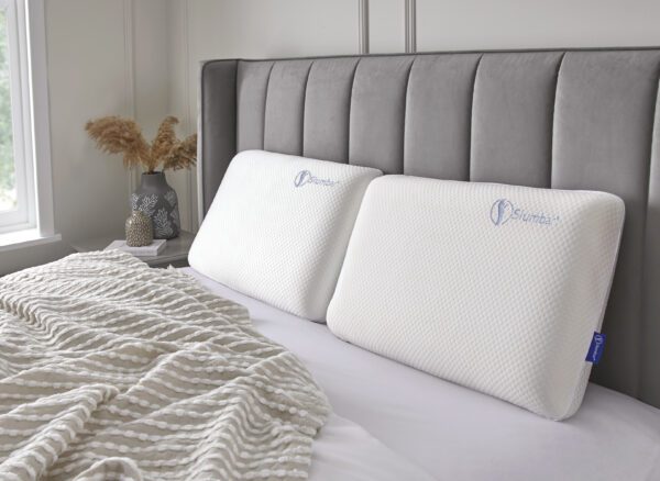 Two Slumbar Memory foam pillows displayed on grey bed