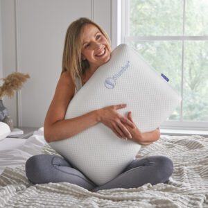 Luxury Memory foam pillow by slumbar being held by a model on a bed